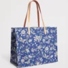 HARRODS Large Cotton Butterfly Tote Bag_3 Harrods 藍色女用托特包印花細節特寫,布滿精緻花朵與蝴蝶,並點綴經典金色 Harrods 字母商標