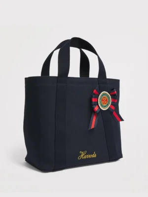 Harrods 藍色重磅厚帆布手提包正面，展示英國勳章軍服絲帶花與亮片徽章細節