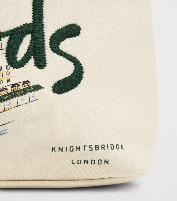 HDBE2630008-00_4 Harrods 城市故事帆布化妝包整體平放,米白底色搭配倫敦地標與 Harrods 門面圖案