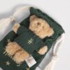 HDDB2620008-55_2-1-mc Harrods Bear in a Pouch 泰迪熊置於星星圖案小袋旁側面細節,展示針織毛衣與絨毛質感