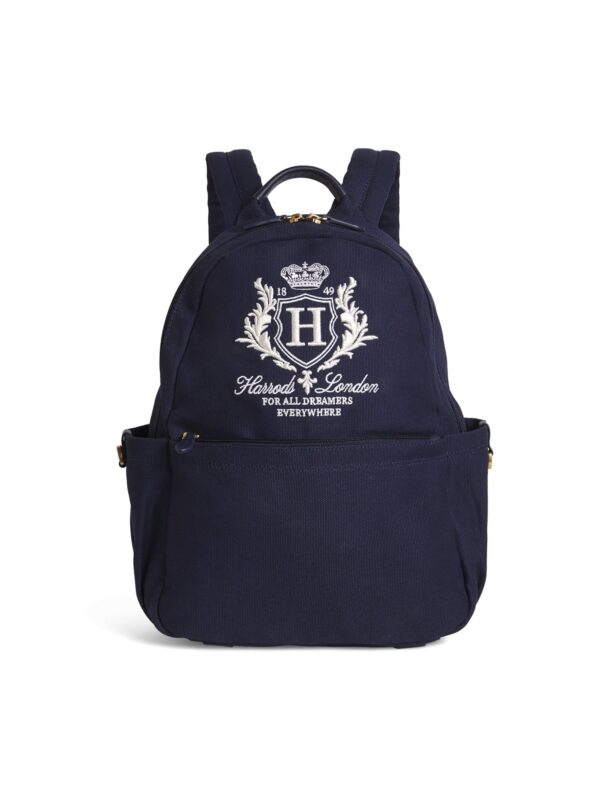 HDBC2542003-69_1-uni 英國 Harrods 海軍藍純棉後背包正面,展示金色刺繡徽章與金色拉鍊五金細節