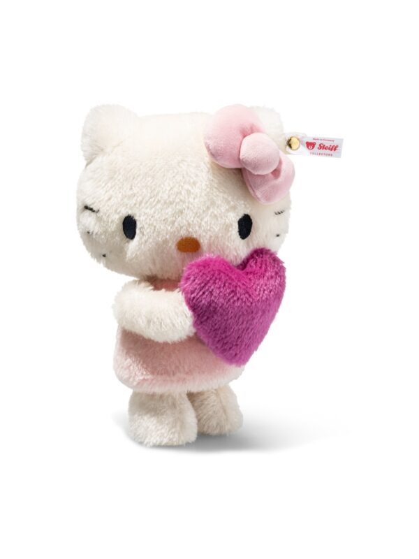 SFDB2630001-00_1-uni STEIFF x Hello Kitty 聯名絨毛娃娃正面全身,白色馬海毛身形懷抱粉色愛心,配戴 24K 金耳釦
